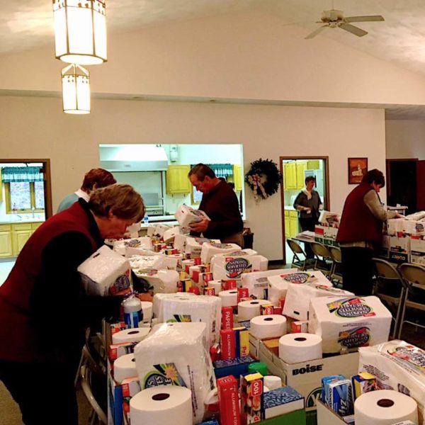 Placing household items in Christ's Bounty boxes in Parish Hall