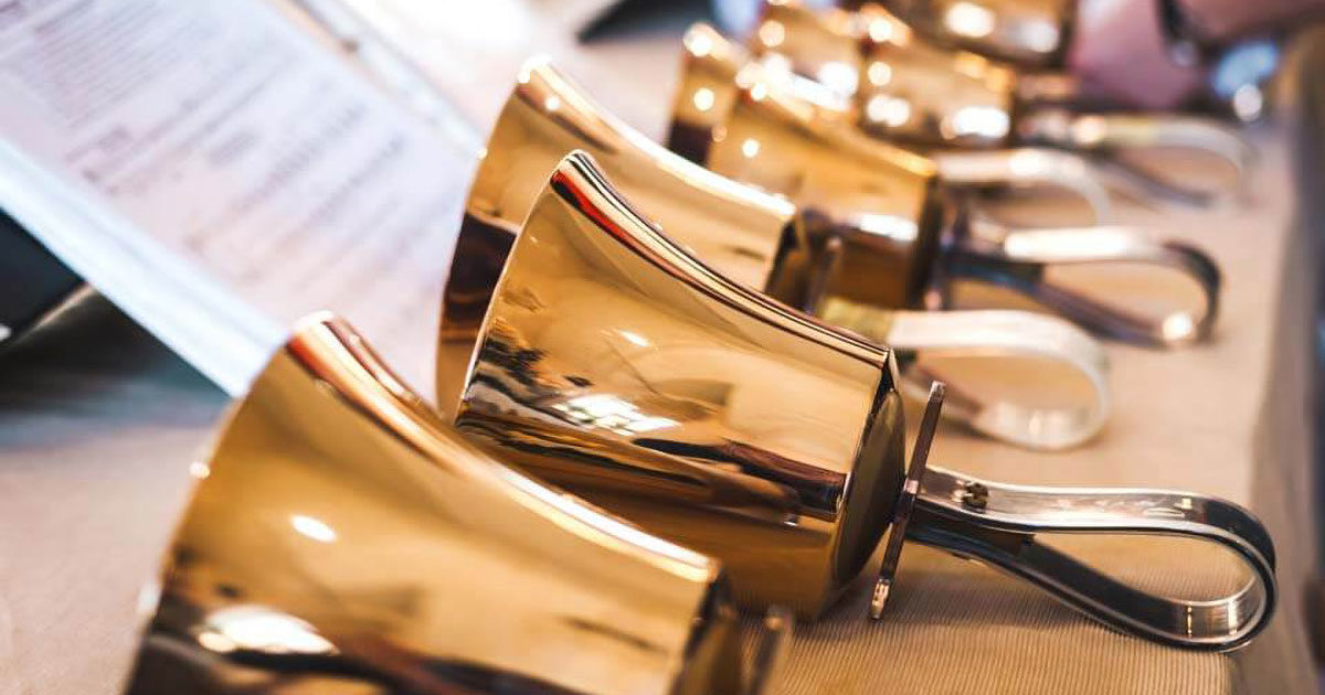 Hand bells on table with sheet music